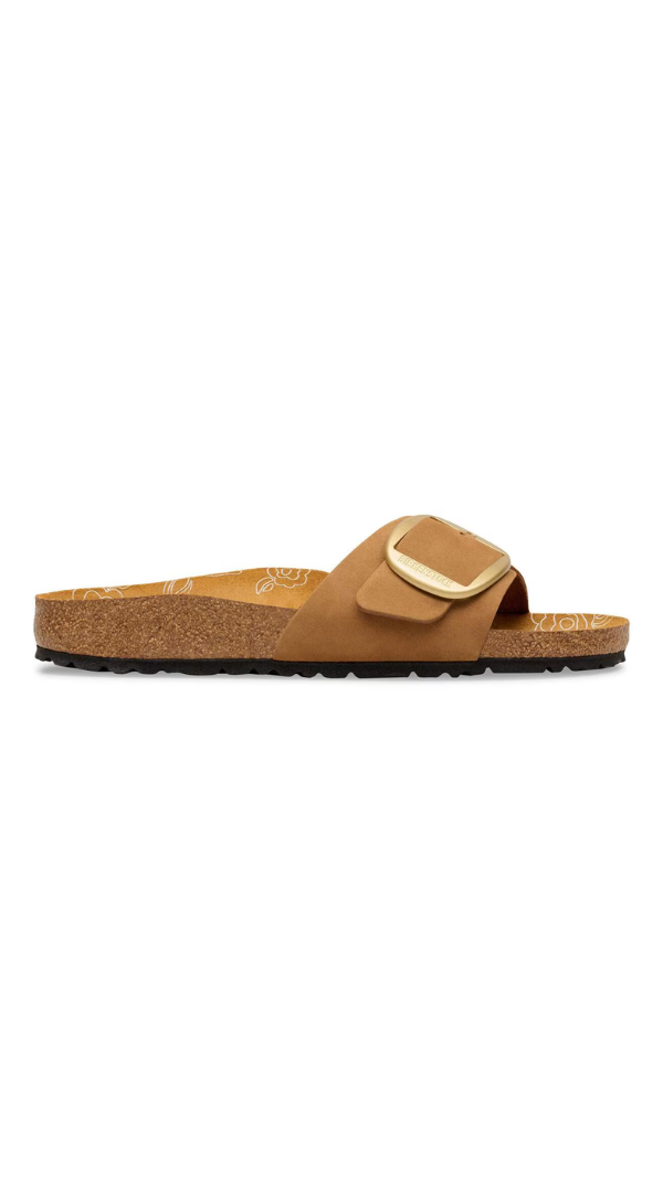 Flat slide sandal with a contoured cork footbed and oversized buckle strap detail