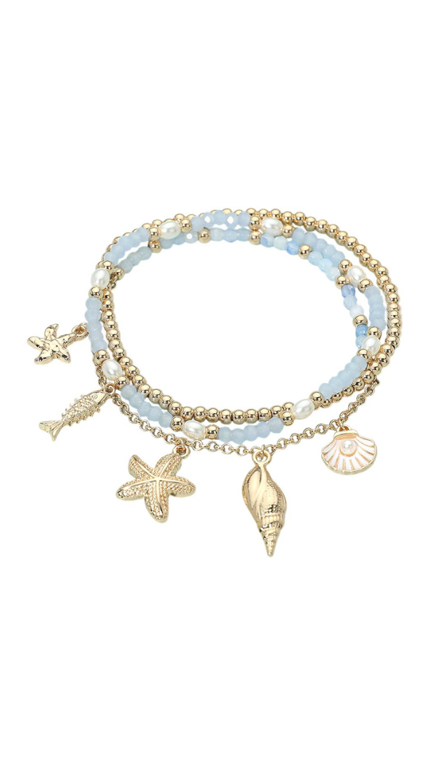 Layered beaded bracelet with light blue beads, gold accents, faux pearls, and starfish, shell, and seashell charms.