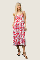 Flowy midi dress with thin straps and allover floral print worn outdoors.