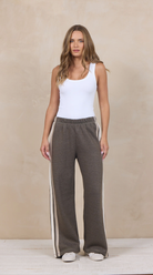 Woman wearing wide-leg heather fleece pants with a varsity side stripe.