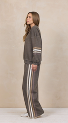 Woman wearing a heather fleece mockneck pullover with dropped shoulders and striped cuffs.