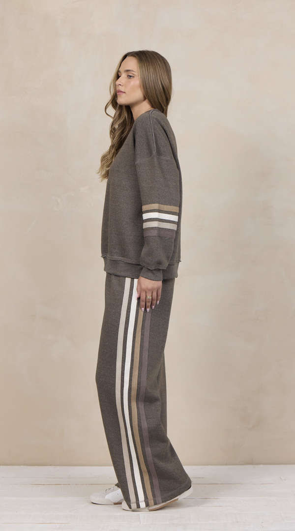 Woman wearing a heather fleece mockneck pullover with dropped shoulders and striped cuffs.