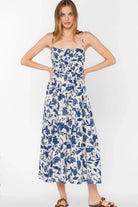 Floral midi dress with fitted bodice, thin straps, and flowy skirt styled with sandals