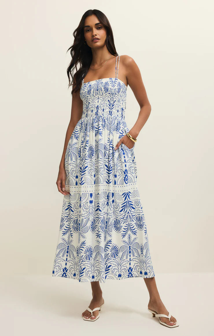 Smocked midi dress with thin straps and flowy skirt styled with sandals