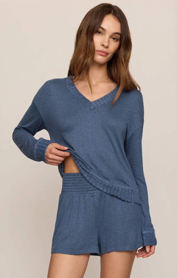 Model wearing a soft V-neck sweater with a relaxed fit and ribbed trim paired with matching lounge shorts.