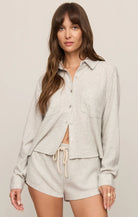 Model wearing an ultra-soft button-front lounge shirt with chest pockets and a relaxed fit paired with matching drawstring lounge shorts.