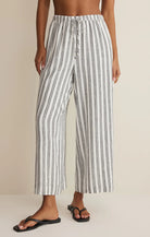 Lightweight pull-on pants with elastic waistband, drawstring detail, and vertical stripe pattern styled with sandals