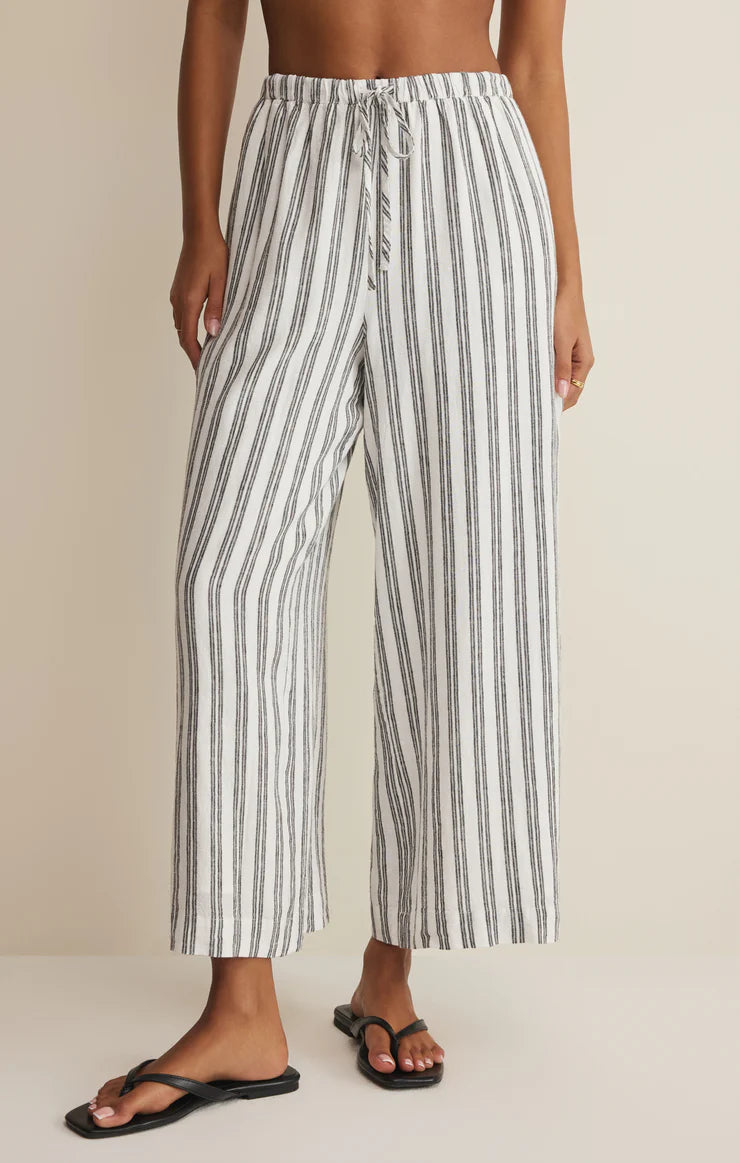 Lightweight pull-on pants with elastic waistband, drawstring detail, and vertical stripe pattern styled with sandals