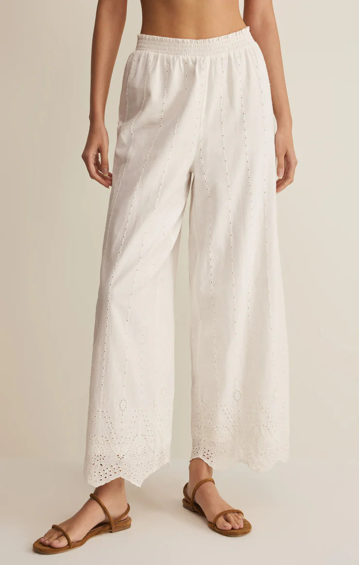 Eyelet wide-leg pants with elastic waistband and scalloped hem styled with flat sandals
