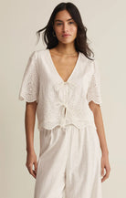 Embroidered short sleeve top with v-neck, tie front, and scalloped hem styled with matching bottoms