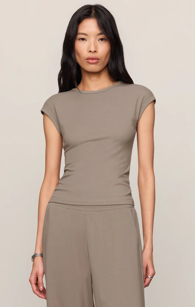 Model wearing a fitted cap sleeve knit tee with a crew neckline styled with relaxed lounge pants.