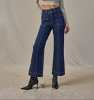 Woman wearing high-rise cropped flare jeans with a double-button waistband, patch pockets, and front seams.