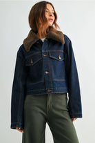 Women’s cropped denim jacket with a removable plush collar, button front, oversized patch pockets, and contrast stitching.