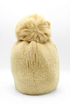 Classic Fuzzy Pom Beanie Beige. This fuzzy beanie features a soft fuzzy fabric with a pom-pom on top, perfect for wearing everyday in the colder months.