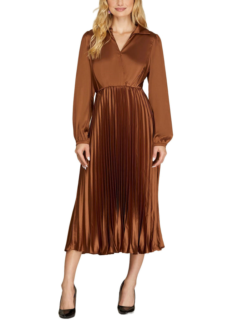 Nina Satin Pleated Midi Dress Toffee. This satin long sleeve midi dress features a surplus neckline and pleated bottom, the perfect dress for any fall festivity or holiday dinner.