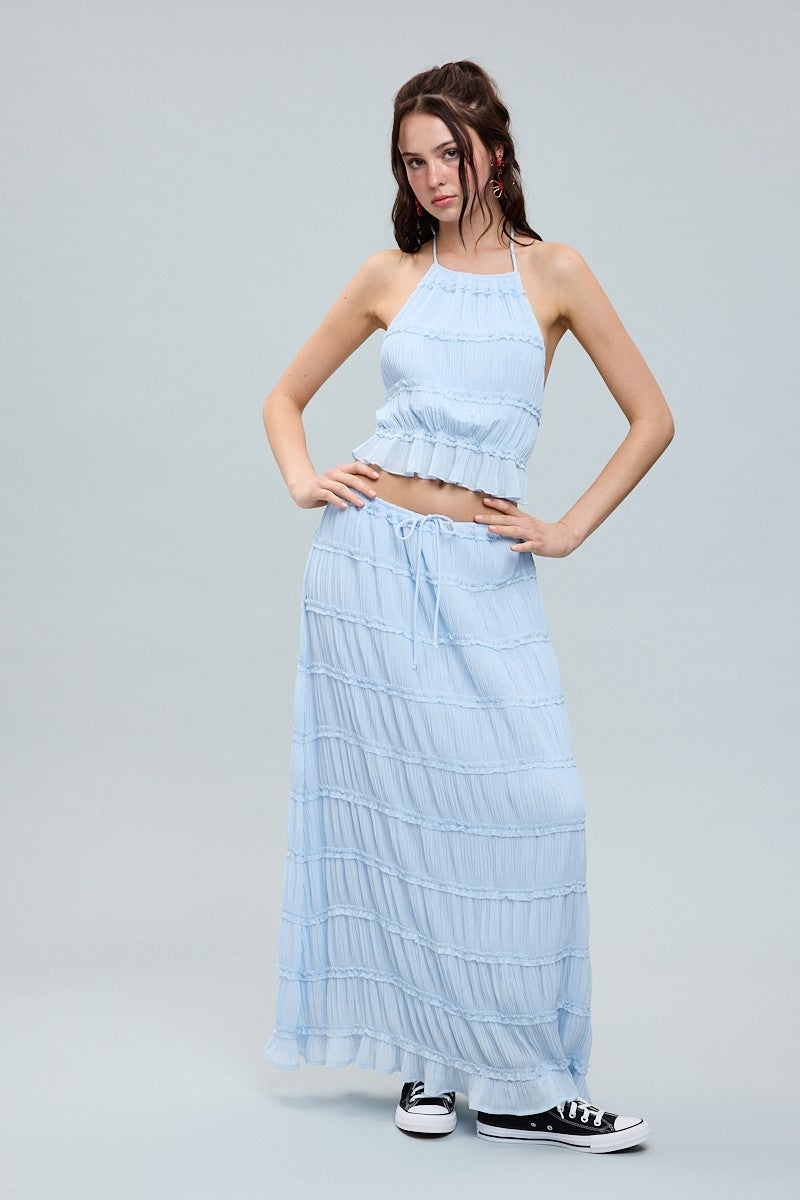 Halter crop top and tiered maxi skirt set with ruffle details and flowy silhouette, styled with sneakers.