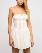 Vania Eyelet Hook & Eye Dress White. This floral print eyelet mini dress features a square neck with adjustable tie straps and hook and eye closures, perfect for the warmer months.