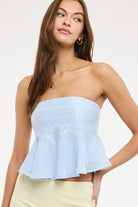 Strapless top with lace detail and flared hem styled with a skirt