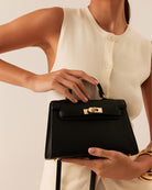 Billini Hariette Mini Handle Bag in Black, carried by hand on model