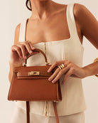 Billini Hariette Mini Handle Bag in Tan, carried by hand on model