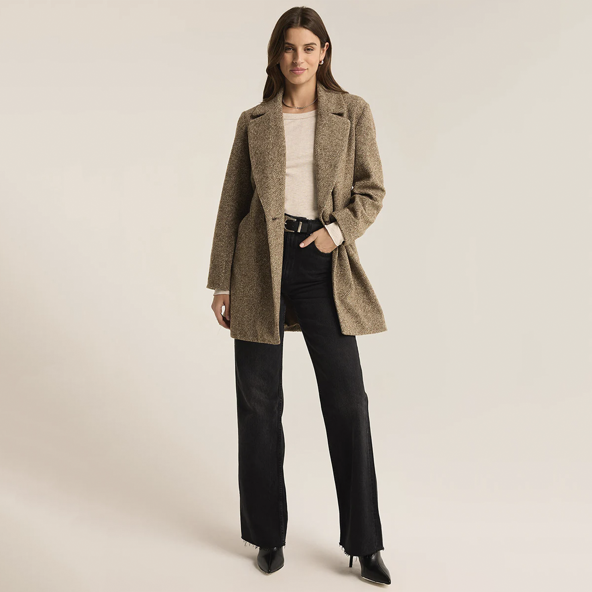 Elevate your wardrobe with the Z Supply Hawthorne Herringbone Coat in Dark Chocolate. Made from midweight fabric, this coat showcases a classic herringbone pattern and is designed with a notch collar, button-front closure, and a belted silhouette. The lined interior and flap pockets combine style and functionality, making it the perfect piece to layer over any outfit for a sophisticated touch.