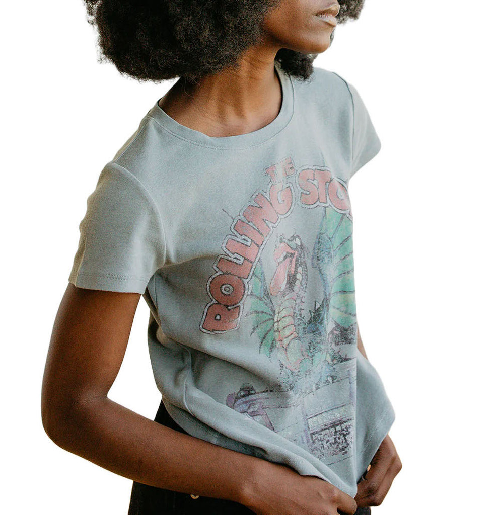 Rolling Stones Dragon Baby Tee Sage. This Rolling Stones Dragon Baby Tee features a graphic pulled directly from an authentic 1981 Stones concert tee. It features a dragon atop an arena, sticking out its iconic Stones tongue. This baby tee is ultra soft and flattering.