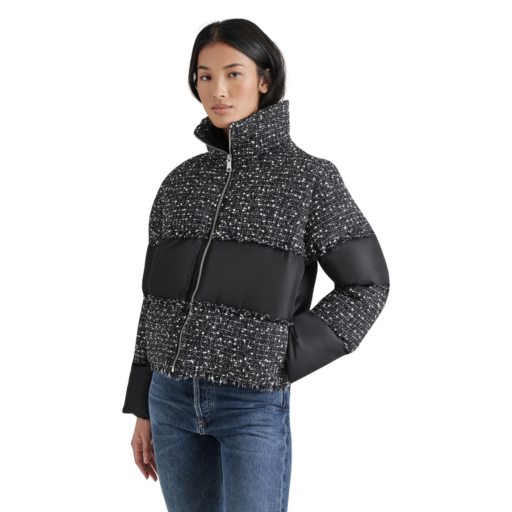 Stay warm and stylish this winter with the Steve Madden Snowdrop Puffer Jacket. Featuring a chic color block design in black and white tweed, this trendy puffer jacket boasts puffy sleeves, a high collar, and a zip-up front for a secure, flattering fit. Perfect for cold-weather fashion, it’s the must-have jacket for women who want to elevate their winter wardrobe.