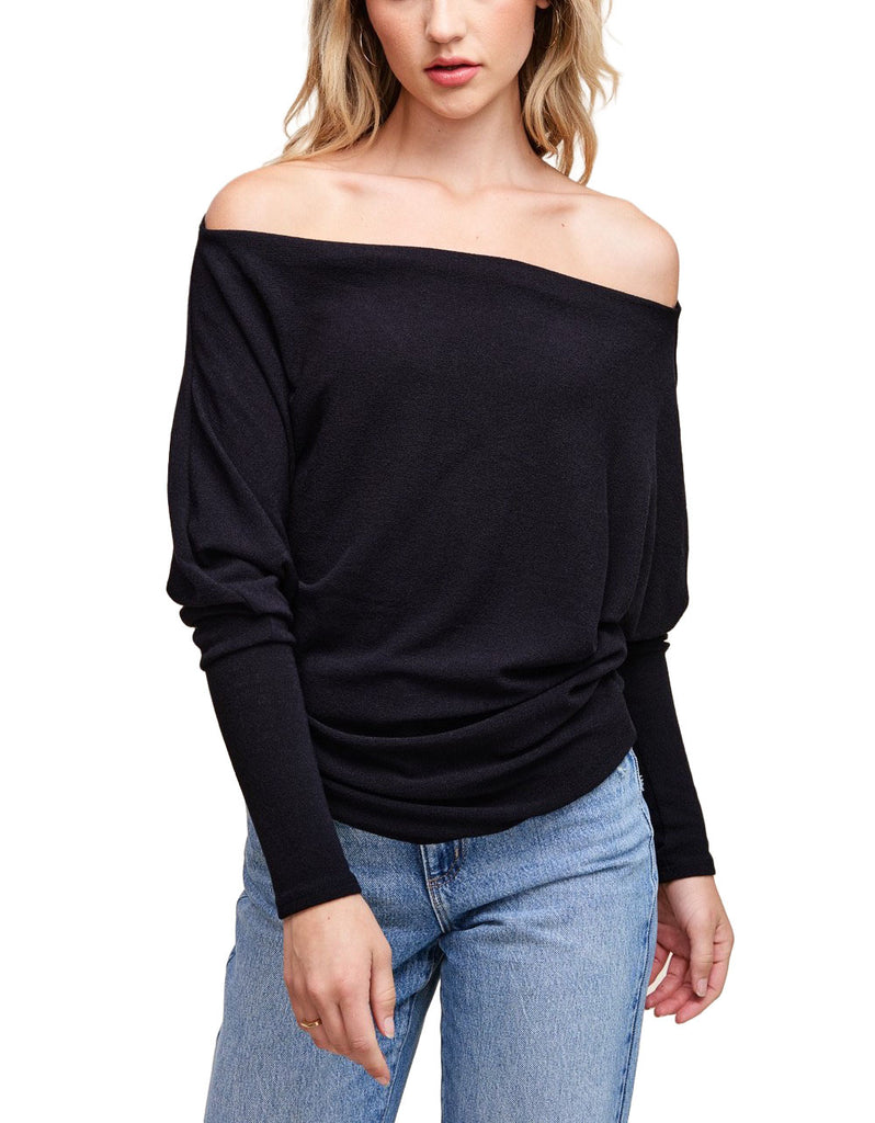 Misi Off Shoulder Crepe Top Black. This off shoulder crepe top comes in a soft hacci fabric and features dolman sleeves and a boat neck collar with an off shoulder design, perfect for any occasion.