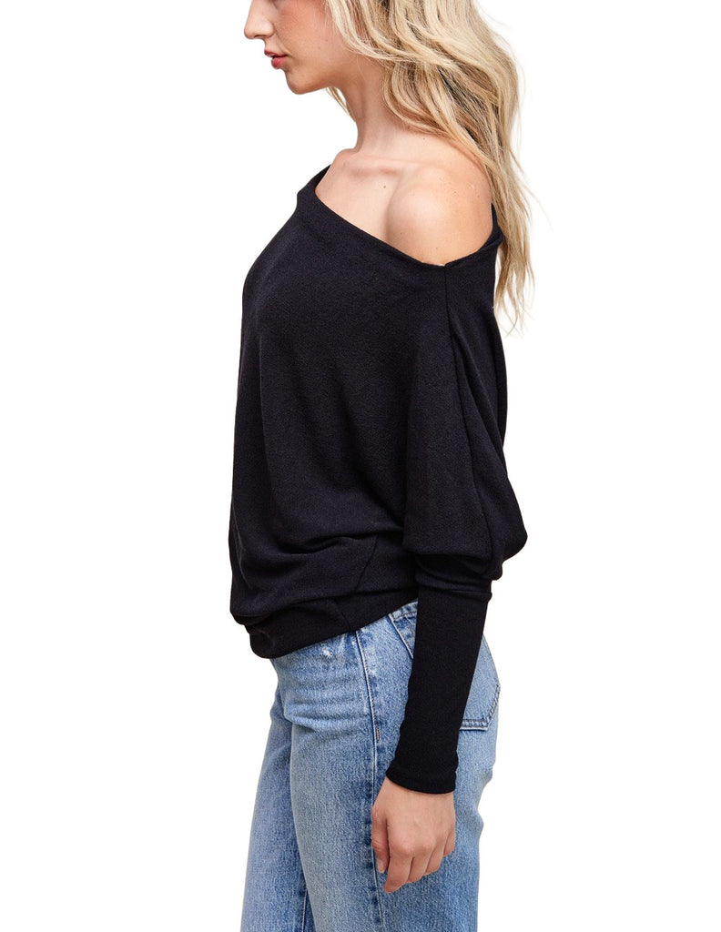 Misi Off Shoulder Crepe Top Black. This off shoulder crepe top comes in a soft hacci fabric and features dolman sleeves and a boat neck collar with an off shoulder design, perfect for any occasion.