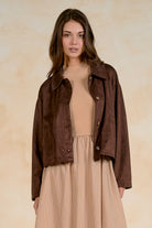 women wearing a faux sueade button cropped faux suede jacket with a collar