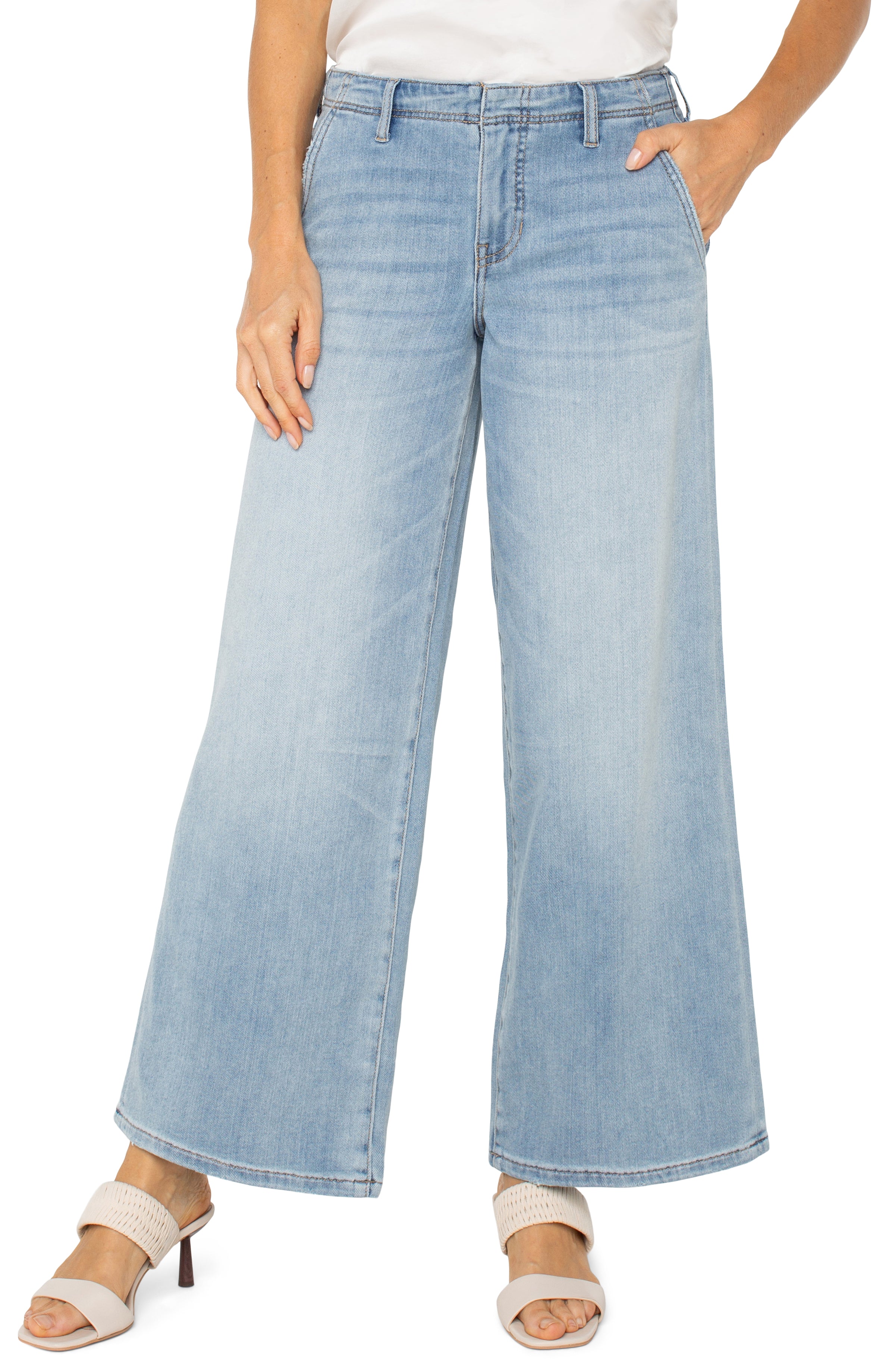 Woman wearing pull on wide leg denim jeans with a relaxed fit and smooth waistband styled with heeled sandals