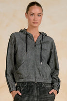 Model wearing a lightweight zip-front hoodie with contrast stripe sleeves, drawstring hood, and front pockets paired with black denim.