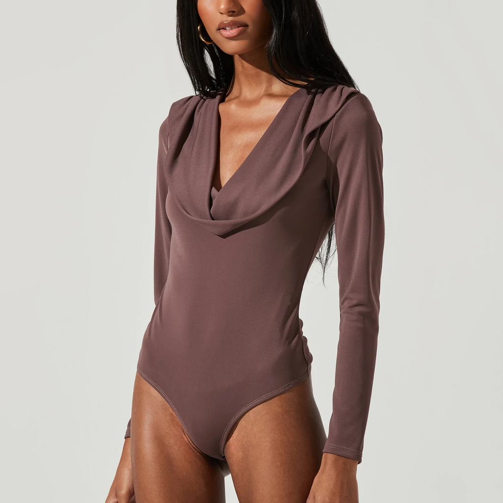 ASTR Kimberly Bodysuit. The Kimberly Bodysuit features a plunging front with a sleek, draped cowl neckline and long sleeves. Attached thong bottoms have snap button closures to stay tucked in to whatever bottoms you choose