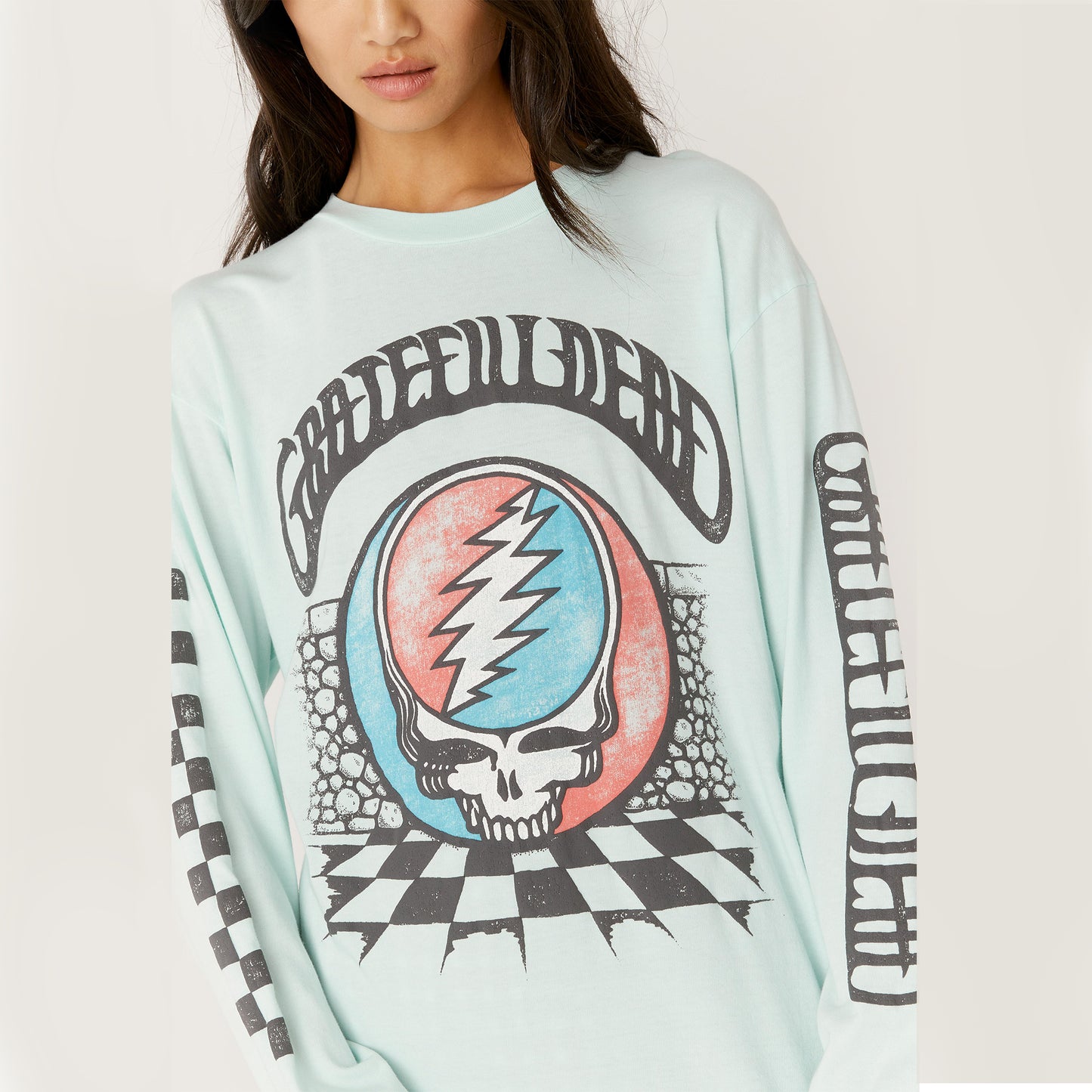 Daydreamer Grateful Dead Checkered Oversized Longsleeve. The iconic Steal Your Face logo gets a checkered update on this Grateful Dead Oversized Long Sleeve. Featuring the original skull and lightning bolt logo, you’ll be easy to spot by both Deadheads and non-fans alike. Complete with checkered graphics on the front and down the right sleeve, this beach glass hued piece finds the ideal balance between classic and edge. Perfect for all occasions, no matter where your long strange trips take you.