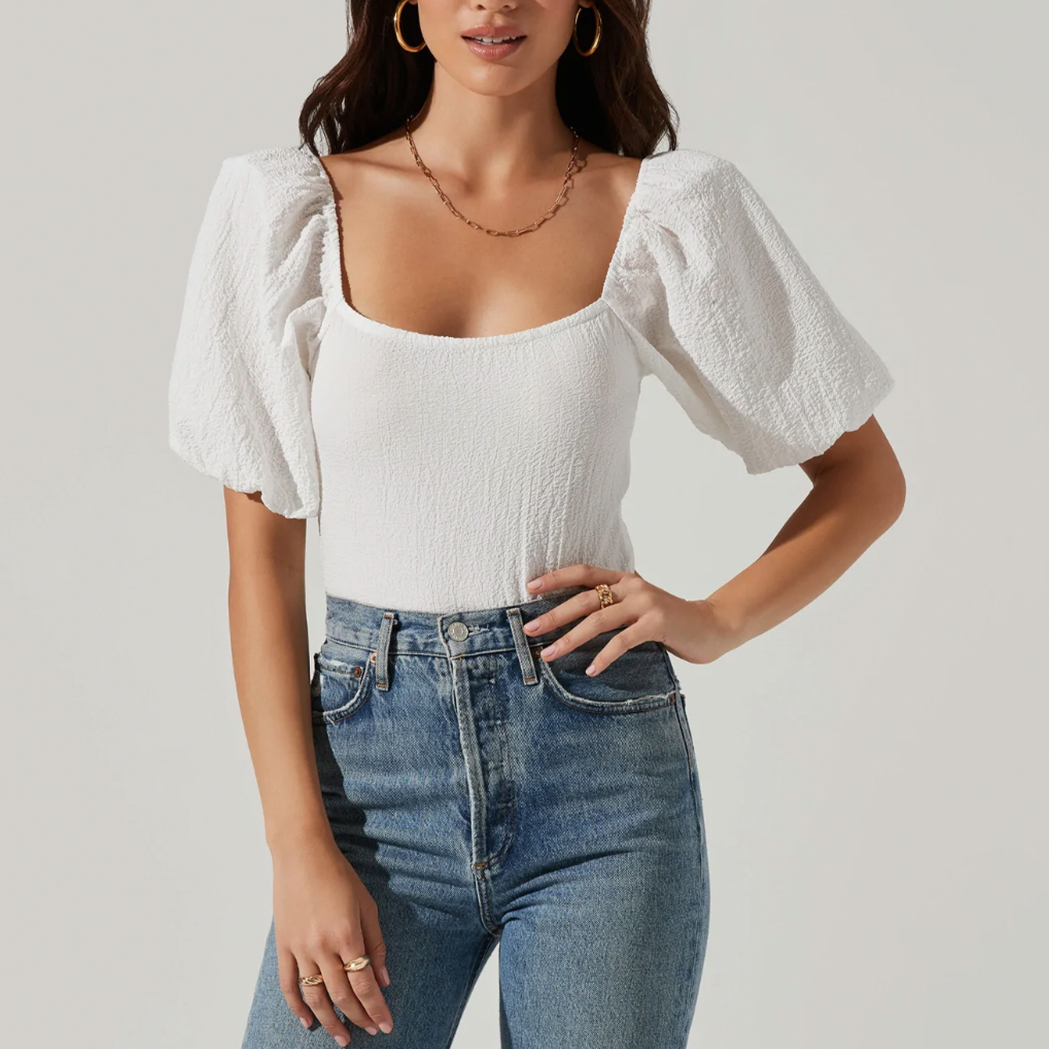 ASTR Puff Sleeve Textured Bodysuit. With a textured fabrication perfect for the season, this bodysuit features a square neckline and statement puff sleeves. Attached thong bottoms have snap button closures. Unlined